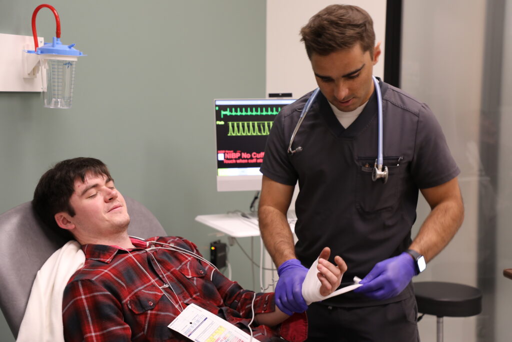 RVU student wraps patient's simulated hand injury in a bandage during a mass casualty simulation.
