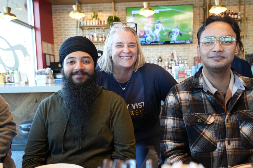 Two international students posed for photo with Director of International Scholar Success