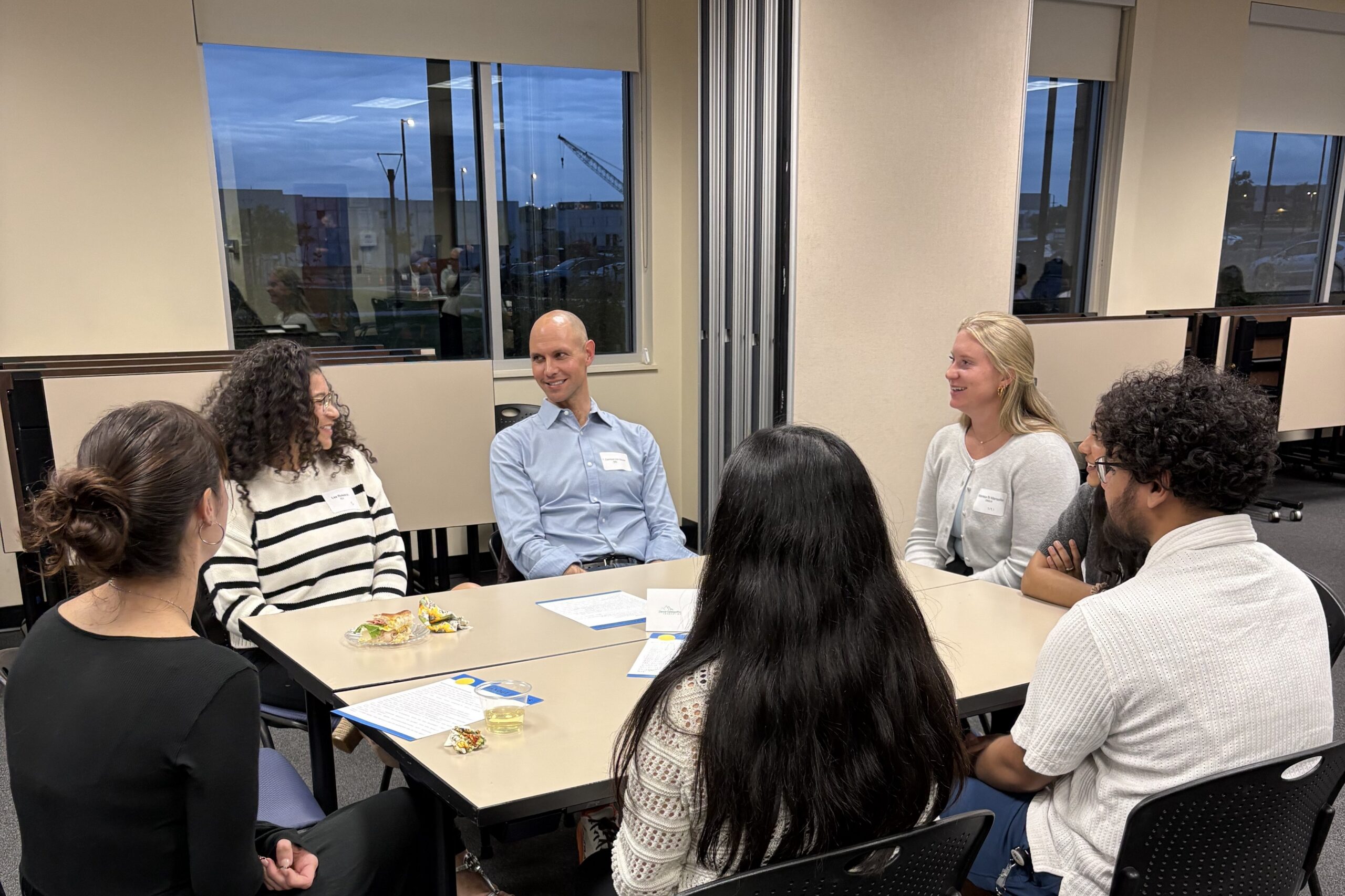Current RVU students sit at a table with a physician to discuss their specialty.