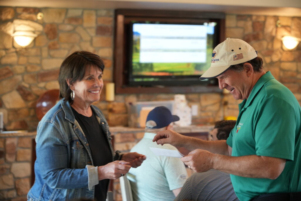 DOF Executive Director, Julie Collett, hands a raffle prize over to a winner during the lunch & awards banquet